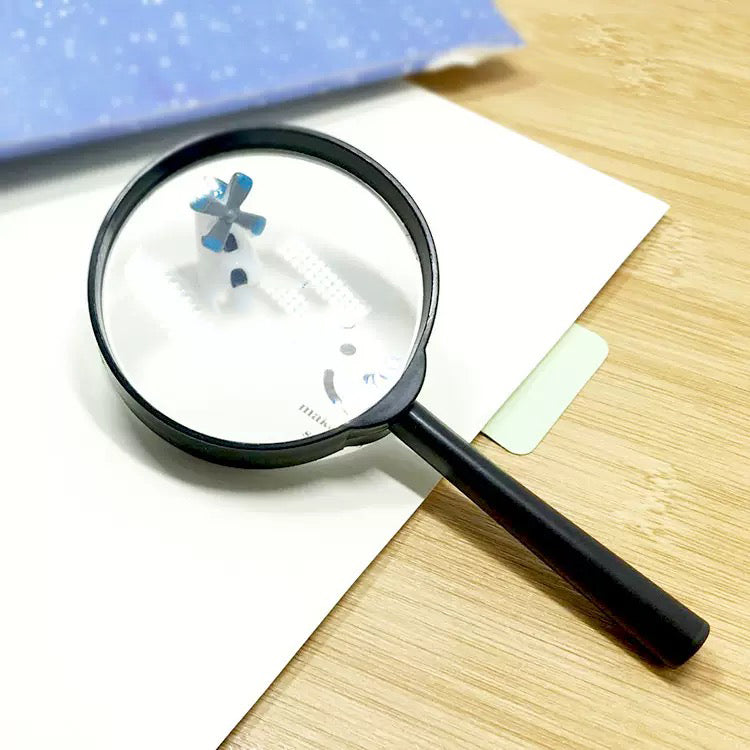 Handheld magnifying glass with a black frame and handle