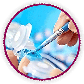 A painting by numbers brush being dipped into blue paint