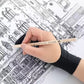 The glove resting on a drawing while the hand works