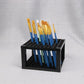 Black grid brush rack holding a set of brushes upright
