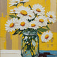 white daisies with orange centers in a glass jar against a yellow wall, paint by numbers kit