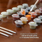 Acrylic paint pots and brushes in several sizes included in the Forest Queen paint by numbers kit